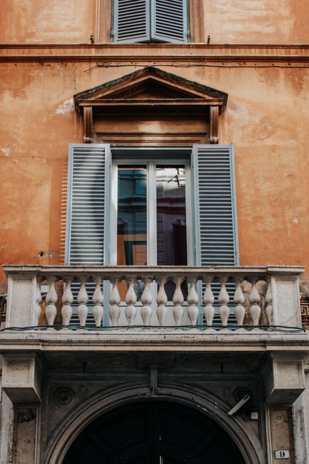 Elegant Roman balcony with classic shutters and architectural details. Capturing historical charm in Rome, Italy.