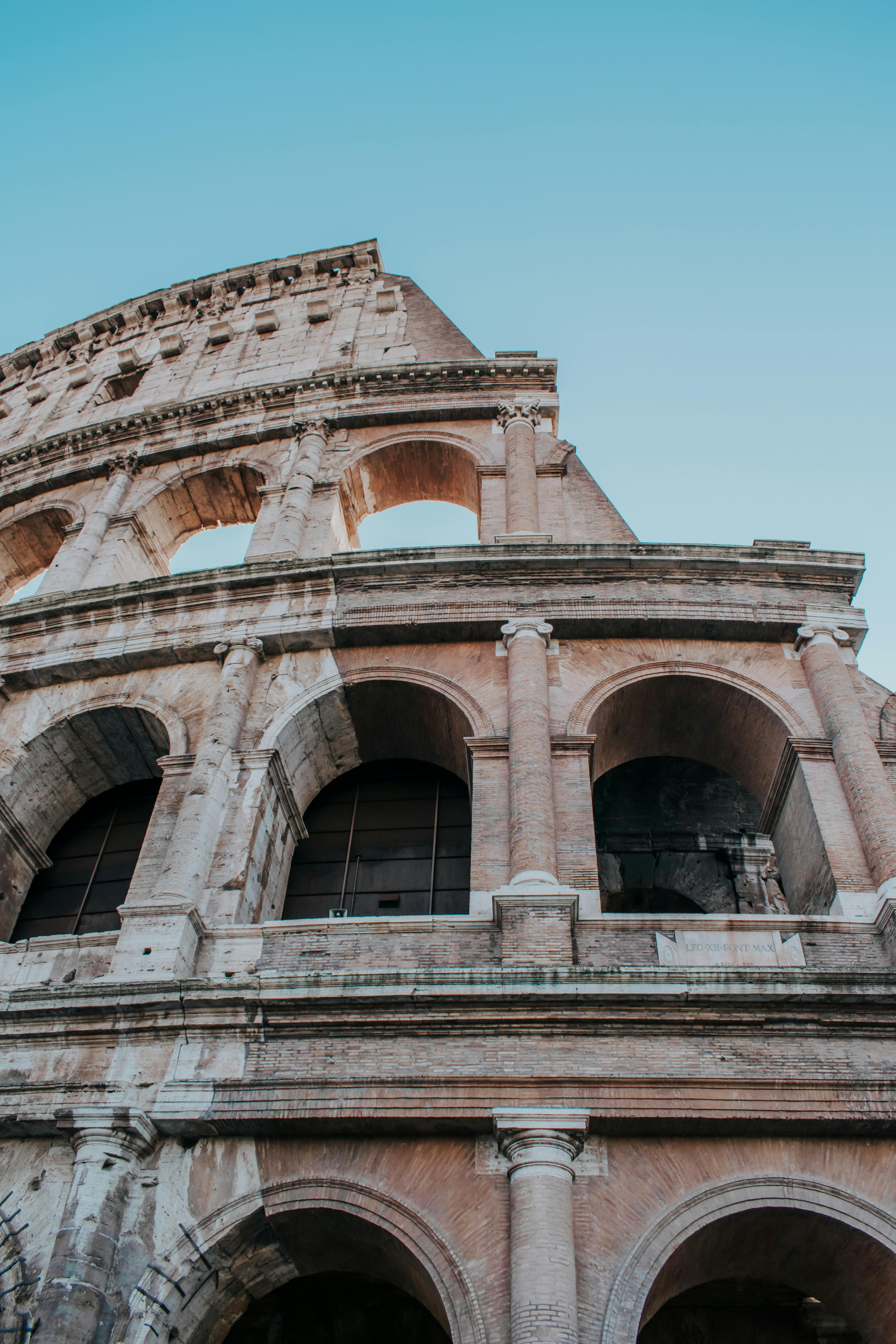 Free Low angle view of the Colosseum's stunning arches in Rome, Italy, against a clear sky. Stock Photo