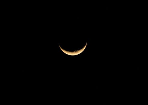 Captivating crescent moon set against a pitch-black night sky, showcasing its serene beauty.