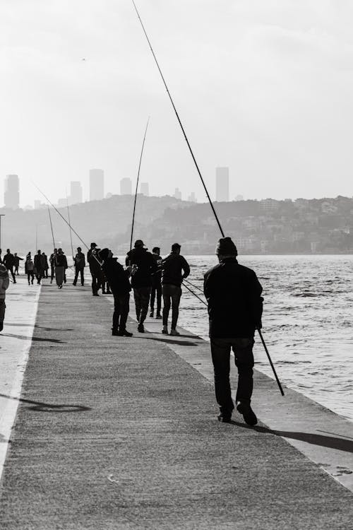 Grayscale Photograph of People Fishing