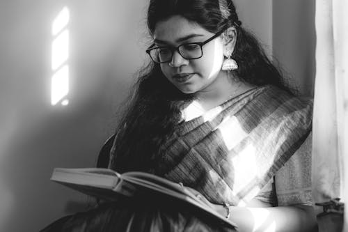Woman Wearing Eyeglasses Reading a Book
