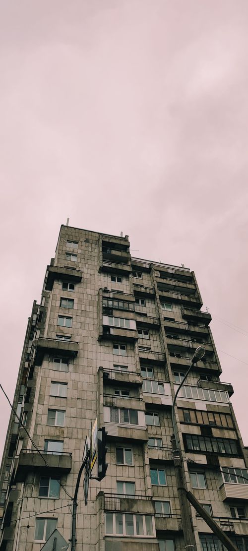 Free Low angle view of a brutalist apartment building against a pink sky. Stock Photo