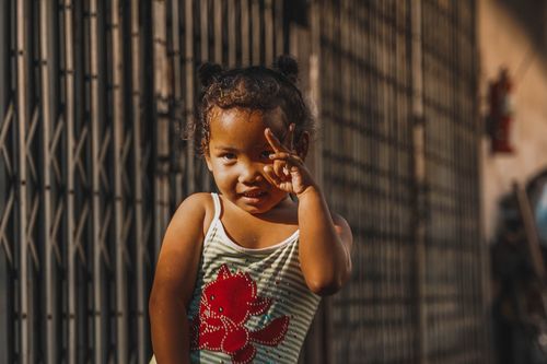 Free Adorable child posing playfully on a sunny day in a Bangkok street. Stock Photo