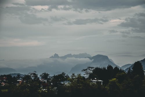 Fotografia De Paisagem De Montanhas E árvores Sob Nuvens Escuras