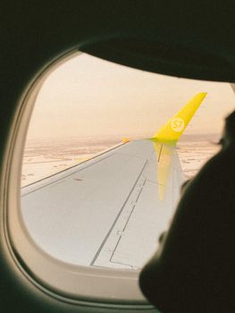 Serene view of airplane wing and horizon from window seat, showcasing air travel.