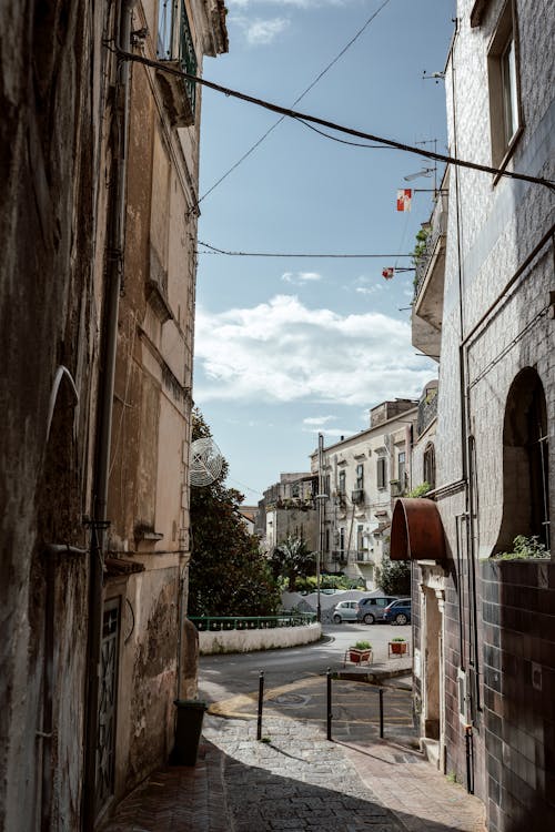 Narrow Road Between Concrete and Brick Buildings