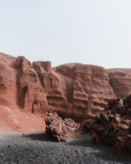 Free Striking red rock formations and volcanic terrain found in Lanzarote, Spain. Stock Photo