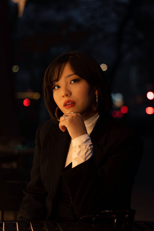 Portrait of a Woman in a Black Blazer Posing with Her Hand on Her Chin