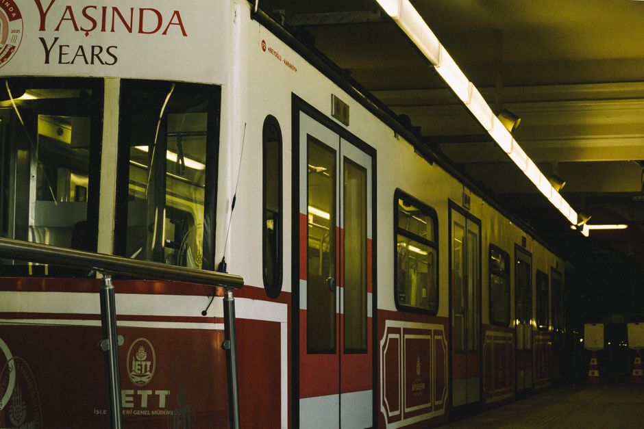 A side view of a red and white subway train at an Istanbul underground station, highlighting urban transportation.