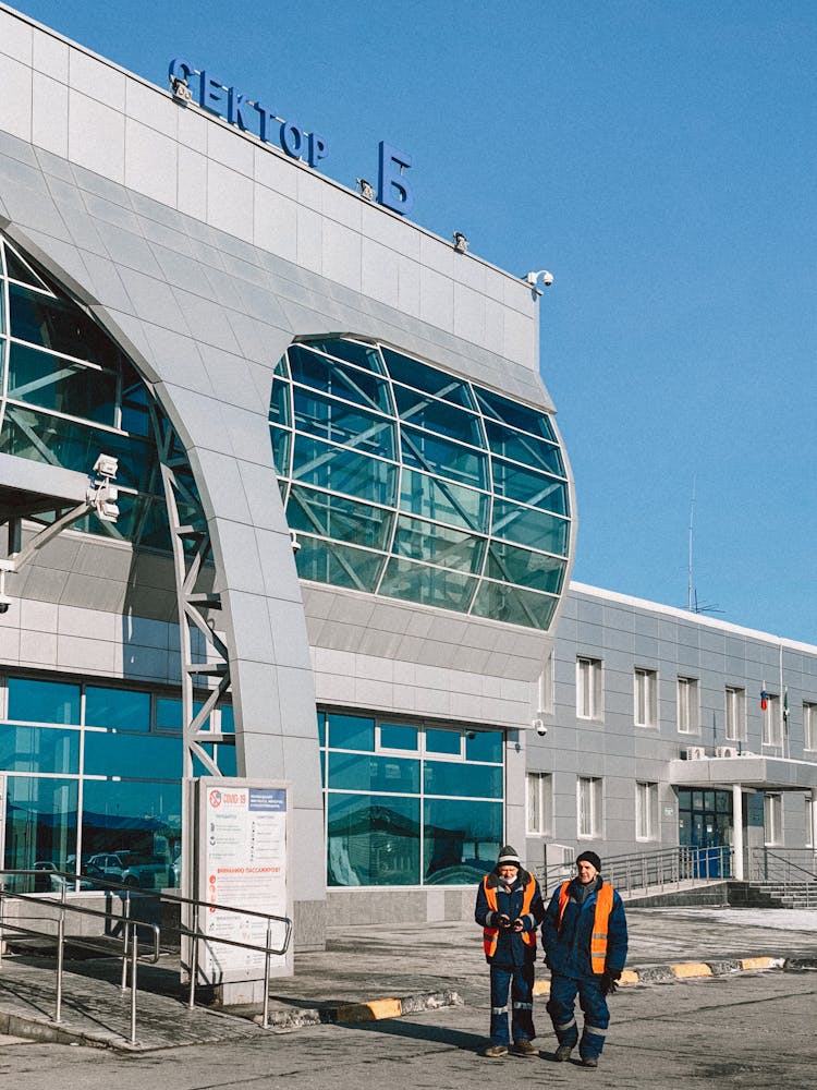 Men In Uniform Walking Outside A Building