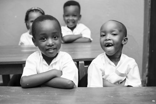 Free Black and white photo of joyful African children smiling in a classroom. Stock Photo