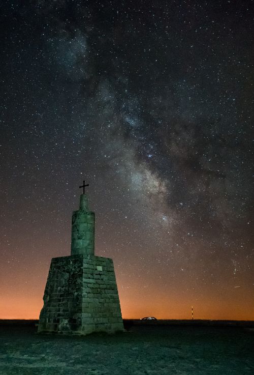 Free Captivating starry sky with the Milky Way above a historic cross structure in Unhais da Serra, Portugal. Stock Photo