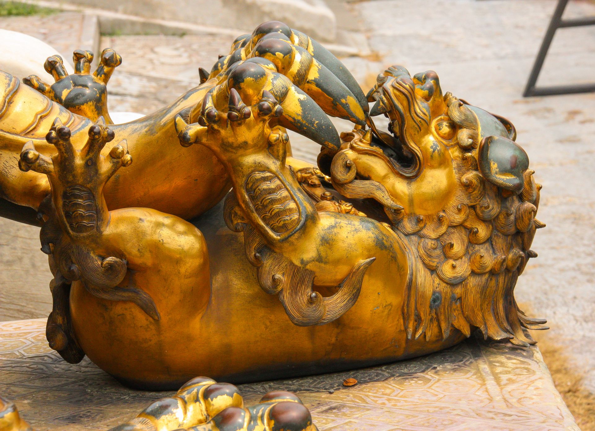 A Statue of a Gold Pixiu Pinned Down by a Claw