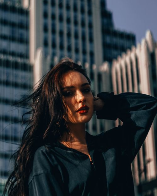 Free Portrait of a stylish woman in Moscow with modern architecture behind her. Stock Photo