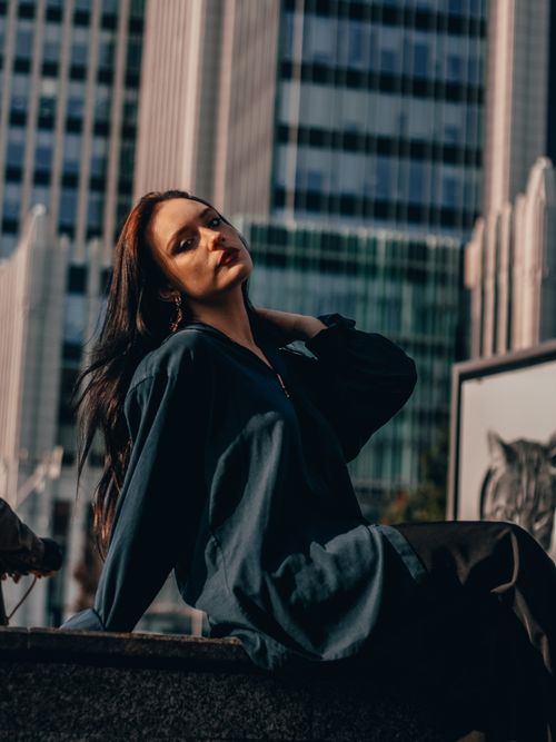 Free Stylish woman posing outdoors against a cityscape in Moscow. Urban fashion with depth of field. Stock Photo