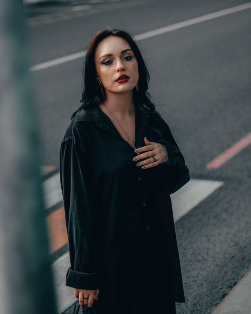 Free Elegant woman in black posing on a Moscow street with a blurred background. Stock Photo