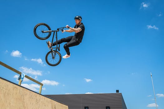 A BMX cyclist performs an impressive aerial trick against a clear blue sky in Moscow.
