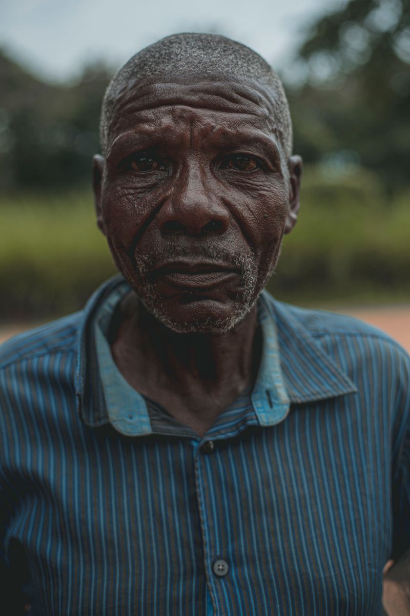 An older Black man with a serious expression, photographed outdoors. The V122I transthyretin variant most often causes heart symptoms in Black adults after age 60.