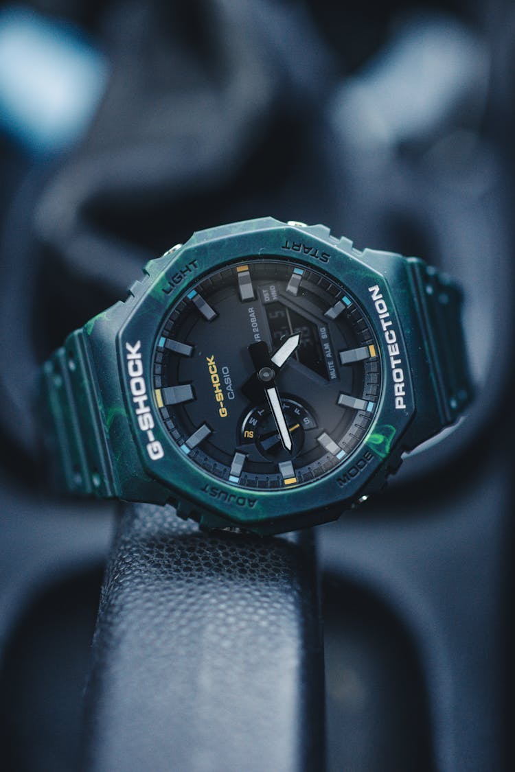 A G-Shock And Casio Wristwatch On A Black Surface