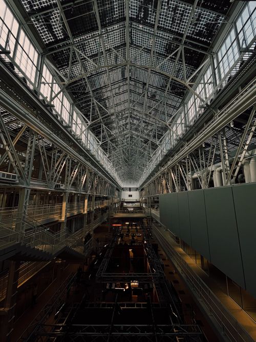 Free Dramatic view of a large industrial building interior showcasing steel framework and expansive ceilings. Stock Photo