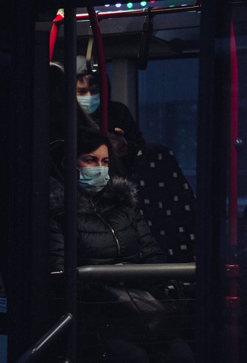 Woman in a Black Jacket Sitting in a Bus