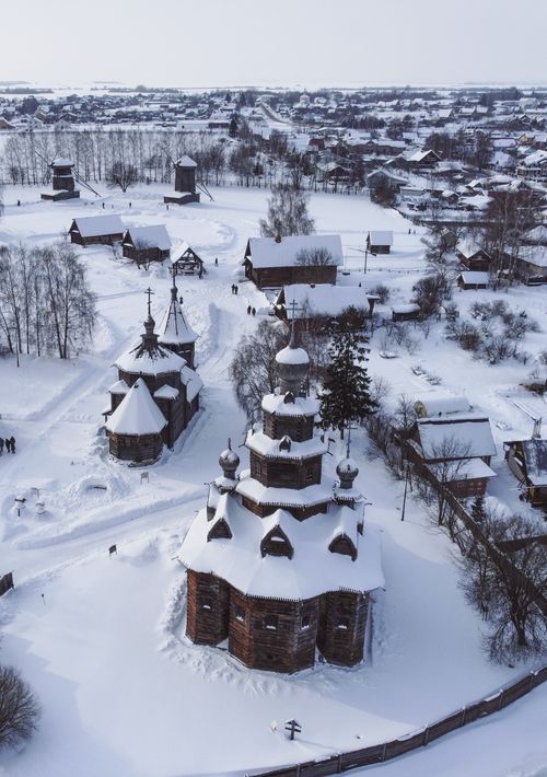 Free Aerial shot of a snow-covered wooden church in rural Russia during winter, showcasing architectural beauty in a frosty landscape. Stock Photo