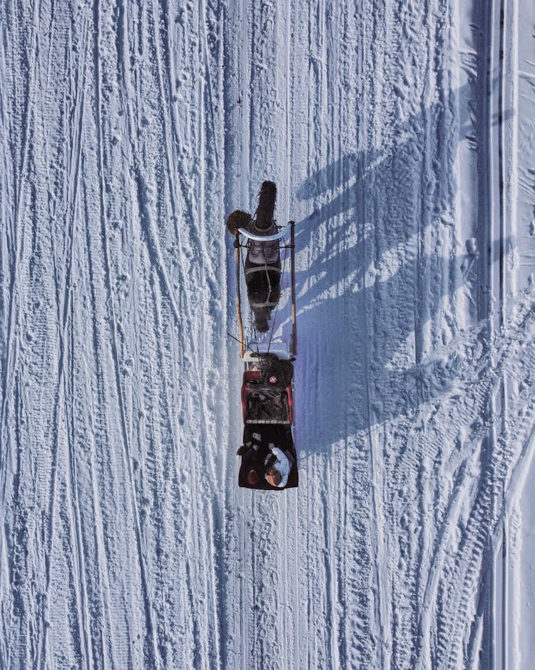 Drone Shot Of People Riding In A Horse Carriage In Winter 