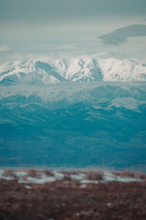 Free Breathtaking view of snow-covered mountains under a cloudy sky, perfect for winter-themed visuals. Stock Photo