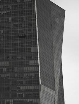 Detailed close-up of a modern skyscraper's geometric glass facade in grayscale.