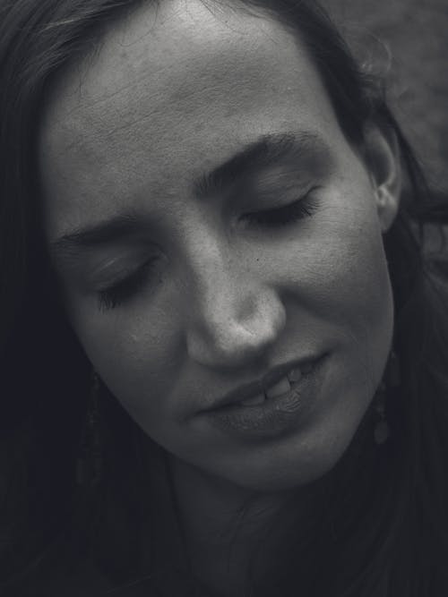 A Grayscale Photo of a Smiling Woman with Her Eyes Closed