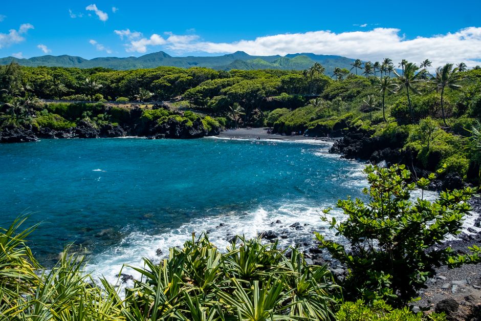 Photo by Kelsey Explore the lush green landscapes and blue waters of Hana Bay, with its unique black sand beach and tropical flora.