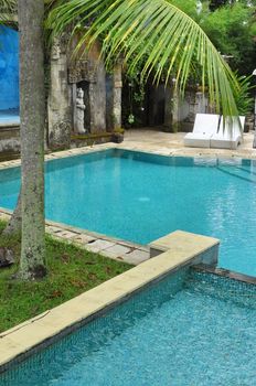Experience ultimate relaxation at this tropical resort with a pristine pool and lush greenery.