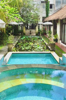 A tranquil luxury garden adorned with a swimming pool and lotus pond, perfect for relaxation and vacation.