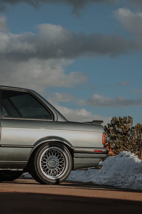 Free Parked BMW E30 on Pavement near Pile of Snow Stock Photo