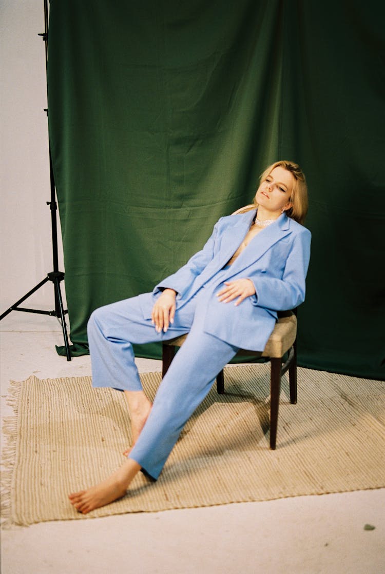 Barefoot Woman In Blue Suit Sitting Casually In Chair