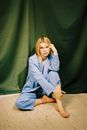 Blond Female Model Sitting on Floor Cross Legged and Posing 
