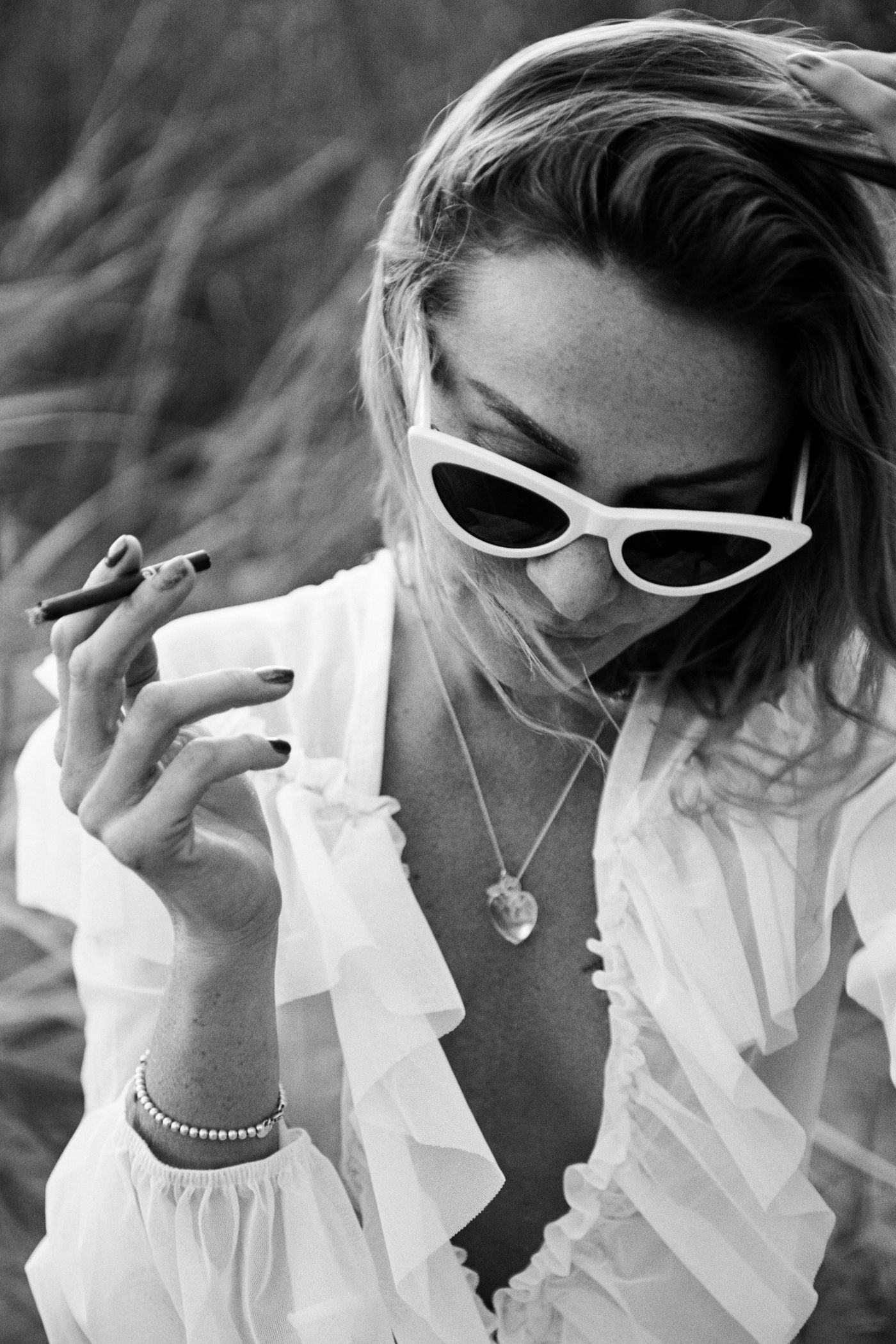 A black and white portrait of a woman in sunglasses — timeless eyewear elegance