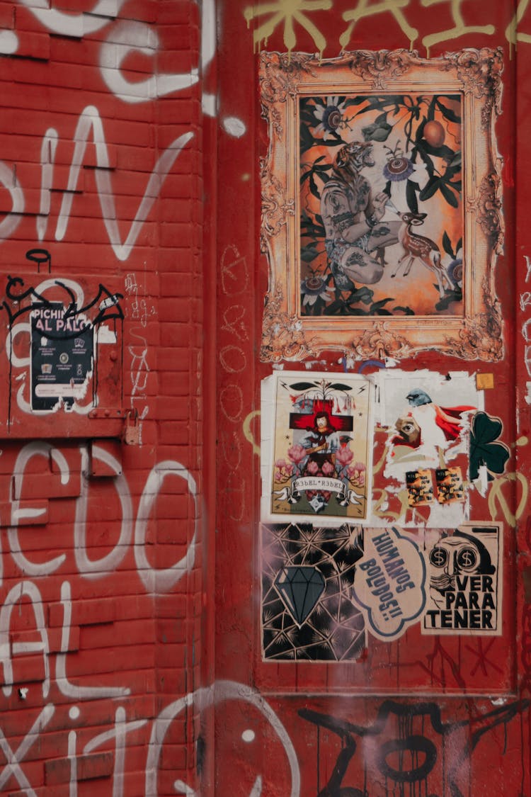 Photo Of A Red Wall With Graffiti And Stickers