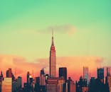 纽约市天际线的彩色日落景观中，标志性的帝国大厦格外引人注目