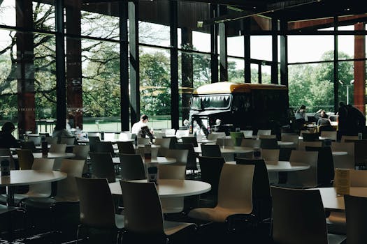 Spacious contemporary restaurant interior with glass walls and modern furnishings in Oxfordshire, England.