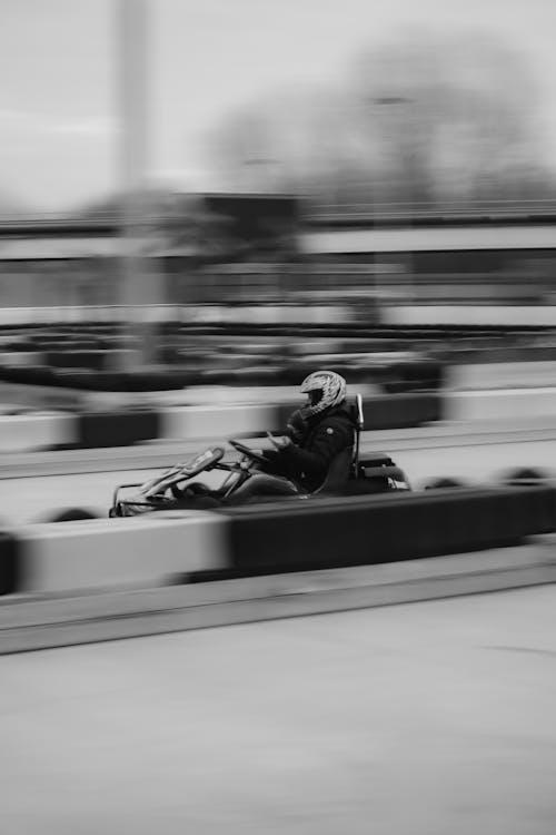 Black and White Photo of a Man Karting 