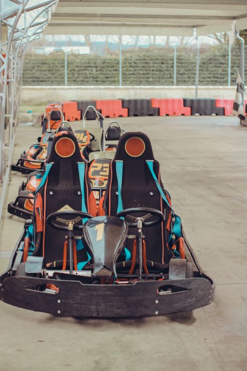 Free Line of colorful go-karts ready for racing on an empty track. Perfect for motorsport enthusiasts. Stock Photo