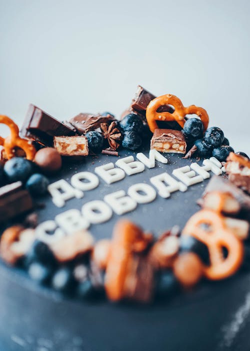 A Black Cake with Chocolate Bars and Blueberries