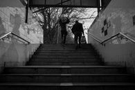 Grayscale Photo of Man Walking on Stairs
