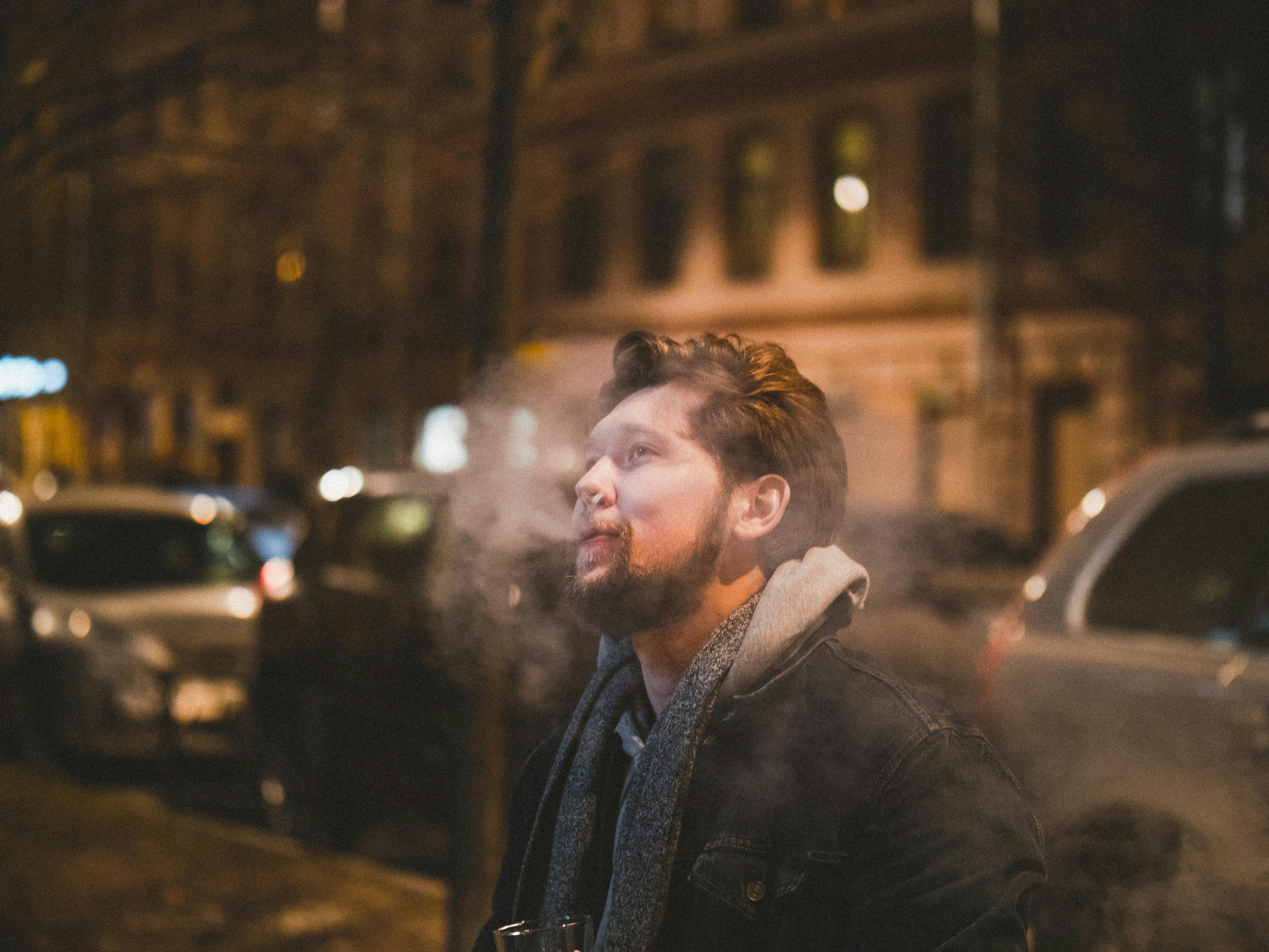 photo of a man exhaling smoke