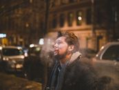 Man in Black Jacket Standing Near Building during Night Time