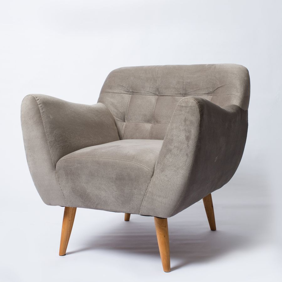 Grey upholstered armchair with wooden legs on a plain backdrop — photo by Ksenia Chernaya on Pexels
