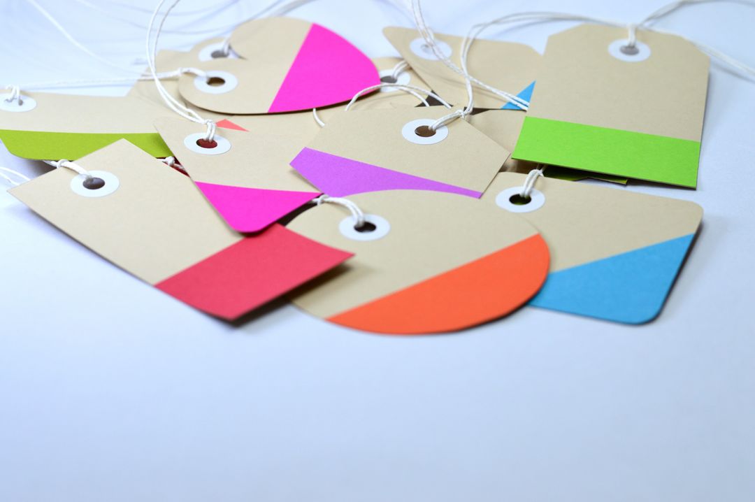 Brightly colored cardboard tags arranged creatively with strings, perfect for design and labeling projects.