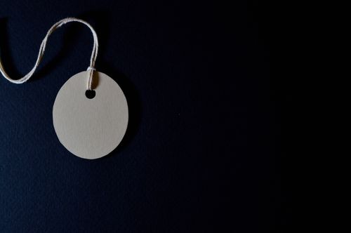 Free An elegant minimalist paper tag with string on a black background. Ideal for design, branding, and packaging concepts. Stock Photo