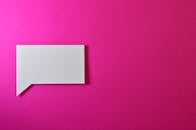 极简主义白纸演讲泡泡置于充满活力的粉色背景上，非常适合设计项目